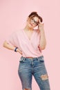 Perky emotional girl in loose pink top and jeans looks up Royalty Free Stock Photo