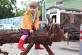 PERM, RUSSIA - JUL 18, 2013: Little girl sits astride city sculpture Kotofeich