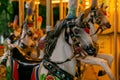 Horse figures on a retro carousel in the evening park