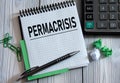 PERMACRISIS - word on a white notepad on the background of a calculator, paper clips Royalty Free Stock Photo