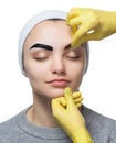 Permanent make-up for eyebrows of beautiful woman with thick brows in beauty salon.