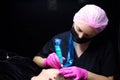 Permanent makeup master performs eyebrow tattooing procedure