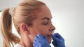 Permanent makeup specialist holds cotton swab disinfects lips before micropigmentation