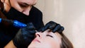A permanent master is doing microblading for a young lady at the studio.
