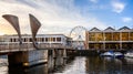 Pero`s pedestrian bridge and the Watershed with Bristol viewing wheel in Bristol, Avon, UK