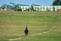 Perosn is riding a horse along a countryside field
