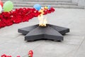 Perpetual fire in the shape of a star burns in memory of those killed in the Second World War among fresh floral tribute. Royalty Free Stock Photo