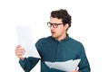 Perplexed businessman looking stunned at paper documents isolated on white background. Confused business person in trouble as Royalty Free Stock Photo