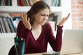 Perplexed female office worker shrugging while looking at laptop Royalty Free Stock Photo