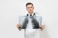 Perplexed focused doctor man with X-ray of lungs, fluorography, roentgen isolated on white background. Male doctor in
