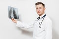 Perplexed focused doctor man with X-ray of lungs, fluorography, roentgen isolated on white background. Male doctor in