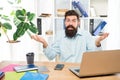 Perplexed guy making helpless gesture working at office desk, perplexity