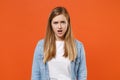 Perplexed shocked young woman girl in casual denim clothes posing isolated on orange wall background studio portrait Royalty Free Stock Photo