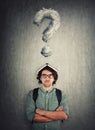 Perplexed student guy with book on his head, looking up tired of constant learning. Puzzled young man not prepared for exams, has Royalty Free Stock Photo