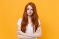 Perplexed young redhead woman girl in white blank empty t-shirt posing isolated on yellow wall background studio