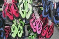 Perranporth, Cornwall, UK - April 9 2018: Reef shoes or aqua shoes hanging up for sale outside a surf shop, in red, blue, green p