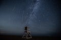 Perseid meteor shower and milky way above a chair on beach