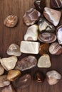 Persian agate heap up stones texture on brown varnished wood background