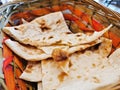 Persian naan flat grilled bread served hot in a wooden basket to eat with traditional curry