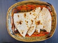 Persian naan flat grilled bread served hot in a wooden basket to eat with traditional curry