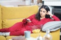 Persian woman at home watching TV and using remote control Royalty Free Stock Photo