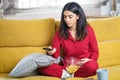 Persian woman at home watching TV and using remote control Royalty Free Stock Photo