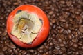 Persimmon closeup on coffee beans.