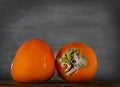 Persimmon. fruits isolated. Sweet exotic fruit at the table, dark background. Orange bowl, tropical fruits, autumn Royalty Free Stock Photo