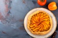 Persimmon galette, pie, tart on a gray stone background. Top view. Selective focus Royalty Free Stock Photo