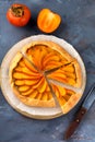Persimmon galette, pie, tart on a gray stone background. Top view. Selective focus Royalty Free Stock Photo