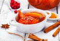 Persimmon jam in small white bowl on wooden background