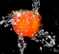 Persimmon in water on a black background Royalty Free Stock Photo
