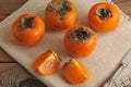 Persimmon whole and cut into pieces on canvas