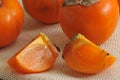 Persimmon whole and cut into pieces on canvas