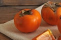 Persimmon whole and cut into pieces on canvas