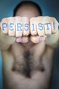 PERSIST! written on the fists of a man