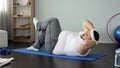 Persistent obese man pumping abdominal muscles doing twisting crunches, sport Royalty Free Stock Photo