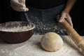 Person adding flour to the kneaded homemade dough