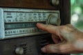 A person adjusting the knobs on an analog radio