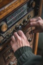 A person adjusting the knobs on an analog radio