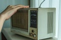 A person adjusting the knobs on an analog radio