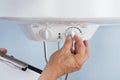 Person adjusting temperature of electric boiler Royalty Free Stock Photo