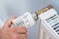 Person adjusting temperature of radiator thermostat Royalty Free Stock Photo