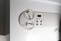 A person adjusts the temperature settings on a home boiler control panel. The close-up image highlights heating Royalty Free Stock Photo