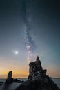 Person admires the tranquil beauty of the milky way galaxy sky from a cliff in Dalian, Liaoning