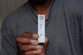 Black man holding positive Coronavirus test