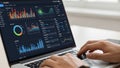 Person analyzing data on a laptop with multiple charts and graphs displayed computer screen Royalty Free Stock Photo