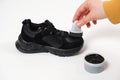 A person applies sponge paint cream to the black crumbs of the child. Care for children& x27;s leather and suede shoes.