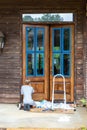 Person applies stain while refinishing wooden front door