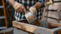 Person applying varnish to wooden planks with a paintbrush. Woodworking and crafts concept